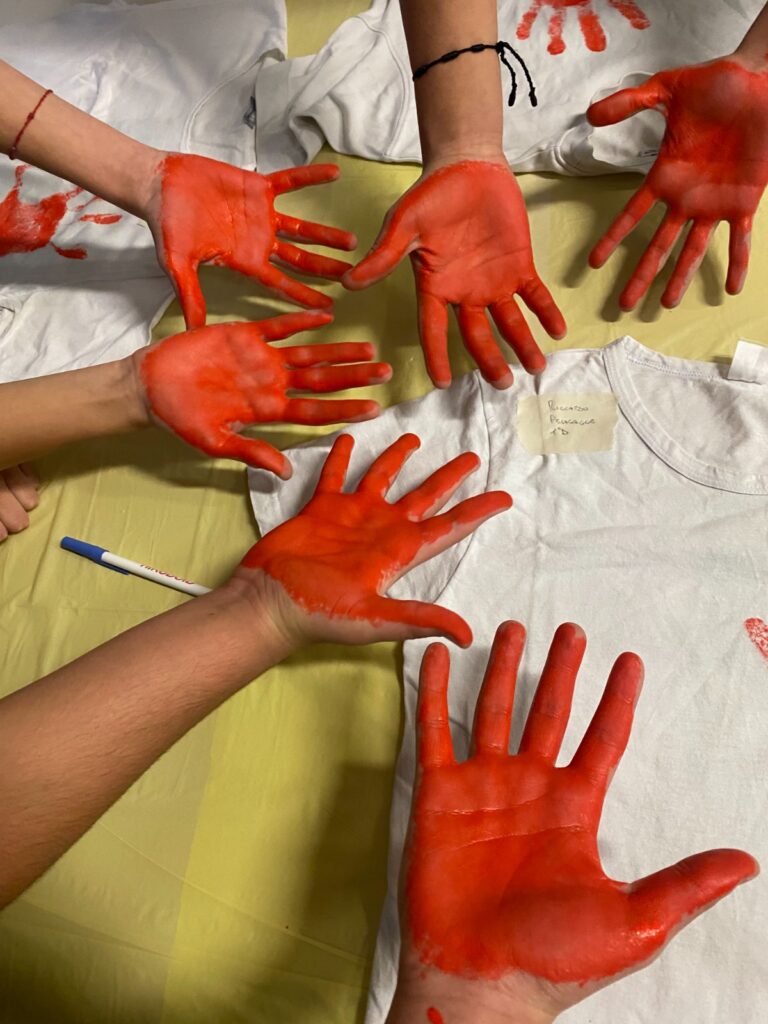 Violenza, le mani intinte nel colore rosso per lasciare una impronta