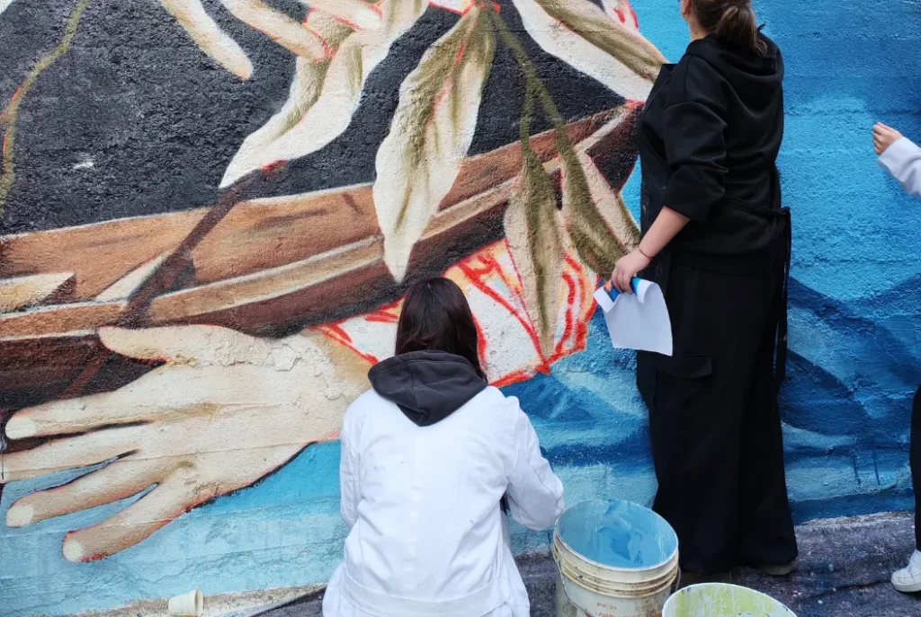 Alcuni studentesse e alcuni studenti del Liceo Classico linguistico Giacomo Leopardi di Macerata che dipingino il Murales insieme alle alunne e gli alunni dell'IES Aguas Vivas di Guadalajara. Per il progetto “Sembrando el cambio/ seminare il cambiamento 