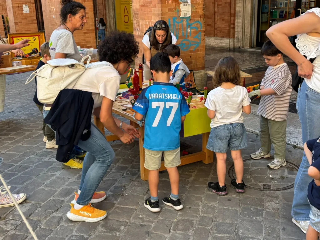 Bambine e bambini giocano nella Strada dei balocchi