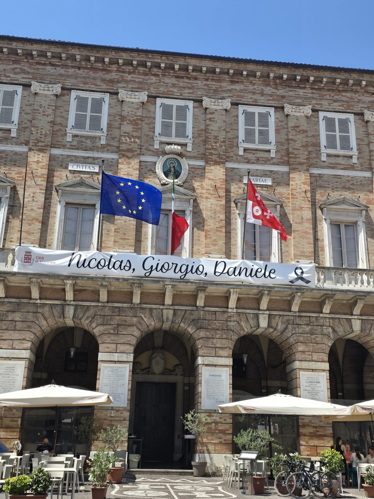 Lo striscione in memoria di Giorgio, Nicolas e Daniele sulla facciata del Comune di Macerata